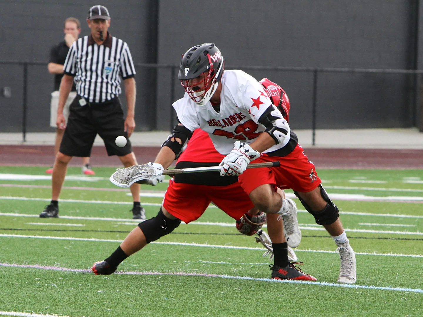 A lacrosse official watches a faceoff during a game